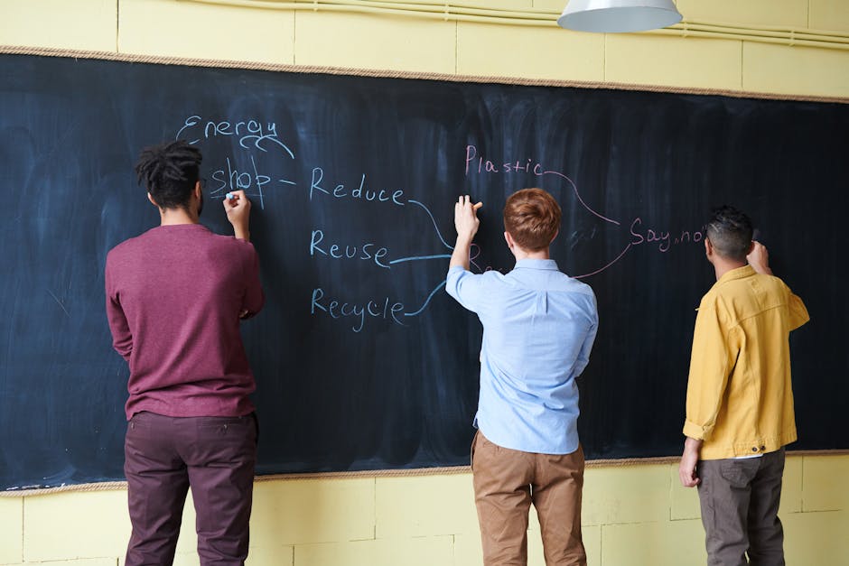 Three students writing on a chalkboard, focusing on reducing plastic and energy waste